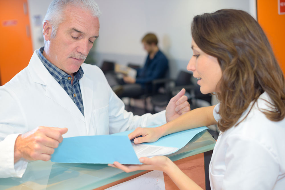 Doctor looking at updated patient information thanks to Preferred Transcriptions fast transcription turnaround times.