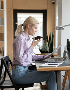 Woman dictating notes while reviewing case file. She'll send to Preferred Transcriptions after.