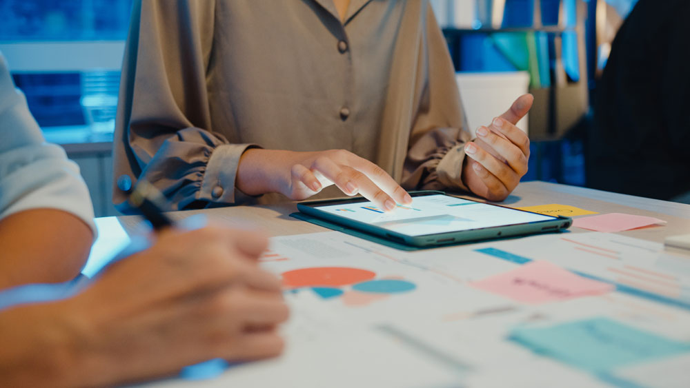 Woman reading full transcript of previous video business training session for faster review.